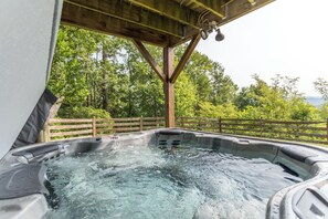 A hot tub under a wooden pergola with a view of trees and a fence. - Grandview Getaway 10 Mins From Parkway, Hot Tub, Private, Ping Pong Table (Deep Gap)