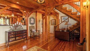 A spacious wooden interior with a staircase, a dining area, and a kitchen. - D-coys Nest (Banner Elk)