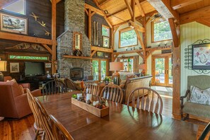 Ein geräumiges Wohnzimmer mit Kamin, Holzbalken und einer Steinwand.