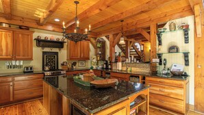 A spacious kitchen with wooden cabinets, granite countertops, and a central island. - D-coys Nest (Banner Elk)