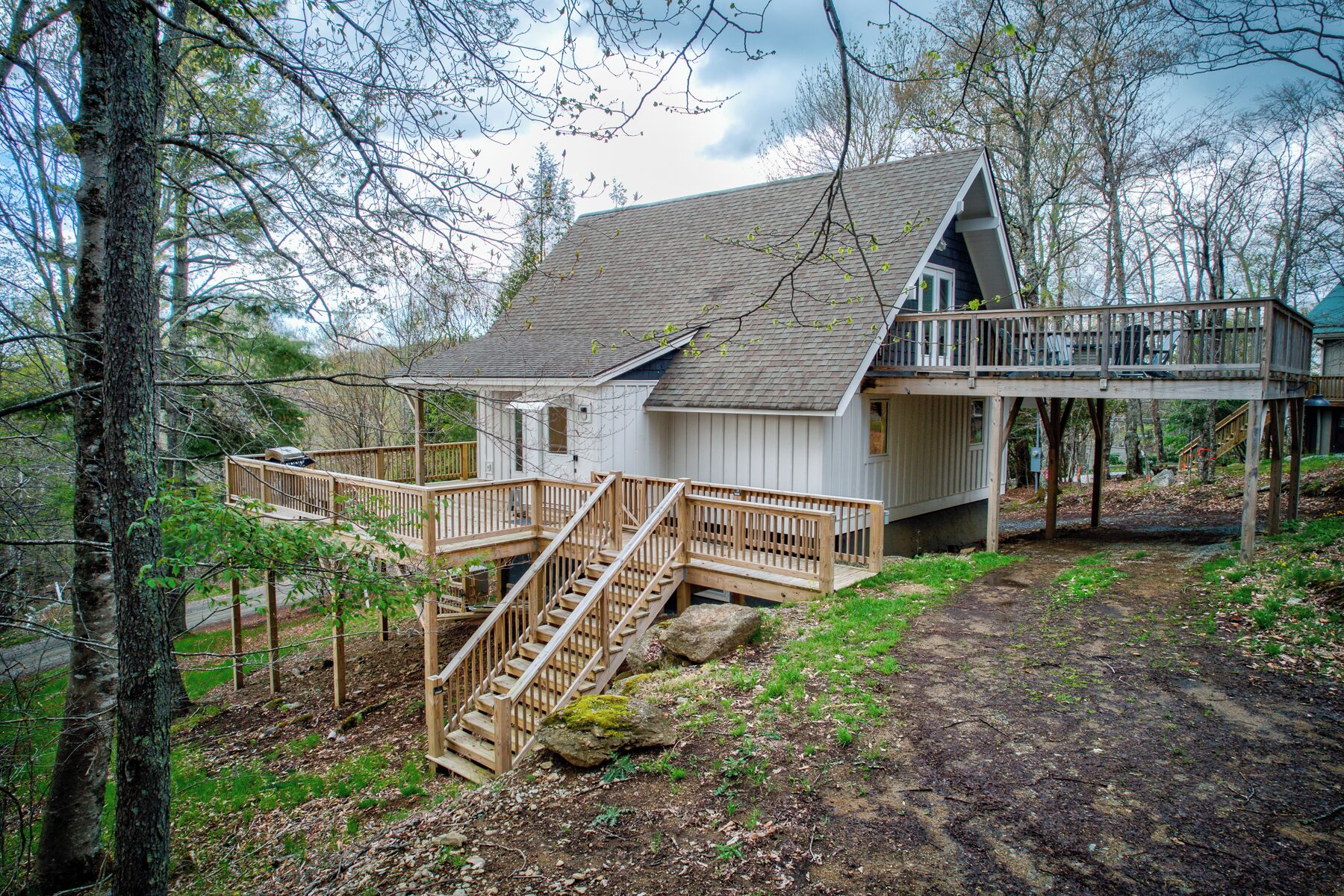 A cabin with a wooden deck, a staircase, and a small porch.