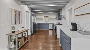 A modern kitchen with grey cabinets, a white countertop, and a coffee station. - Elevation Escape (Banner Elk)