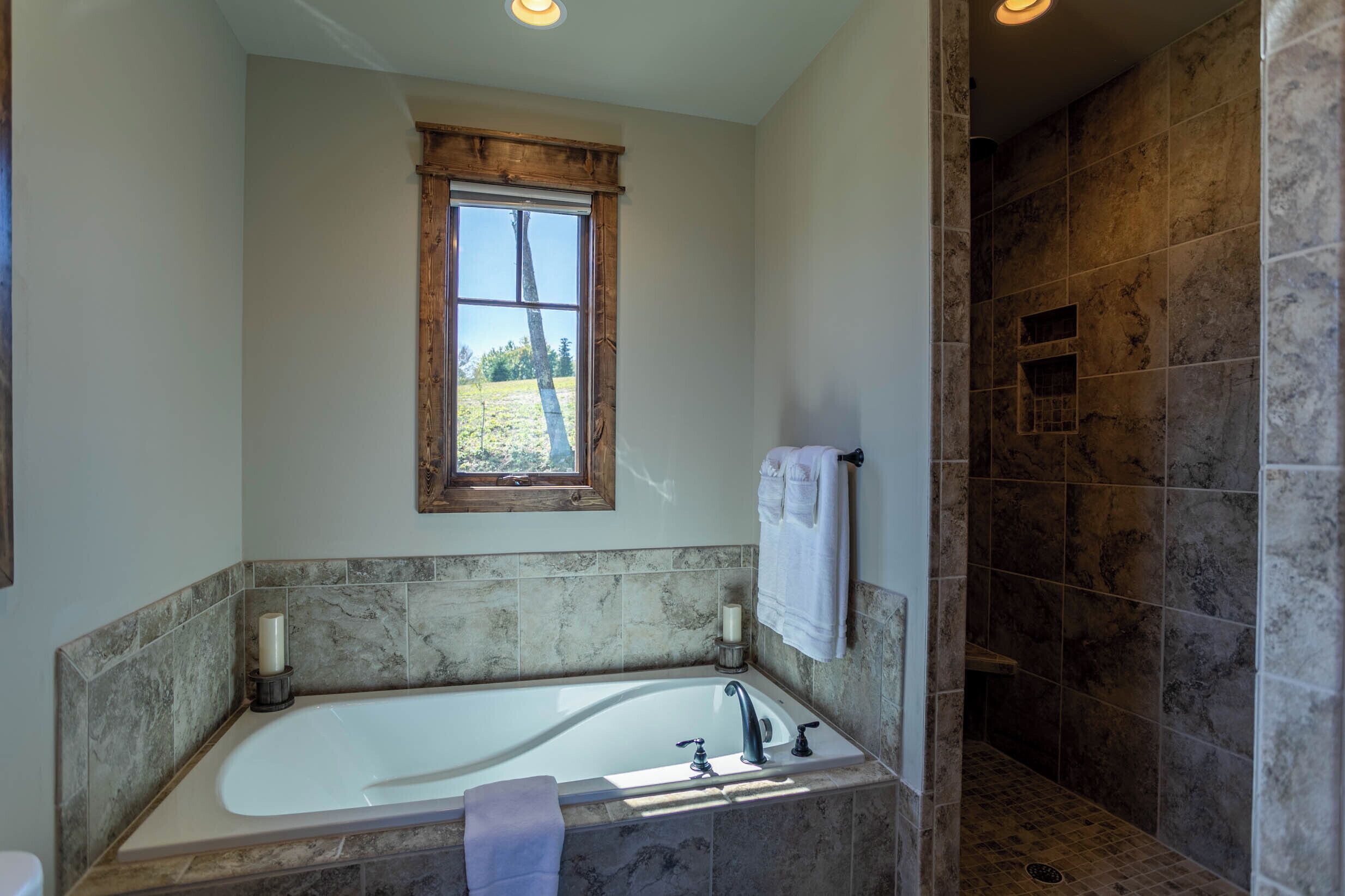 Une salle de bain avec une baignoire, une fenêtre et un espace douche.