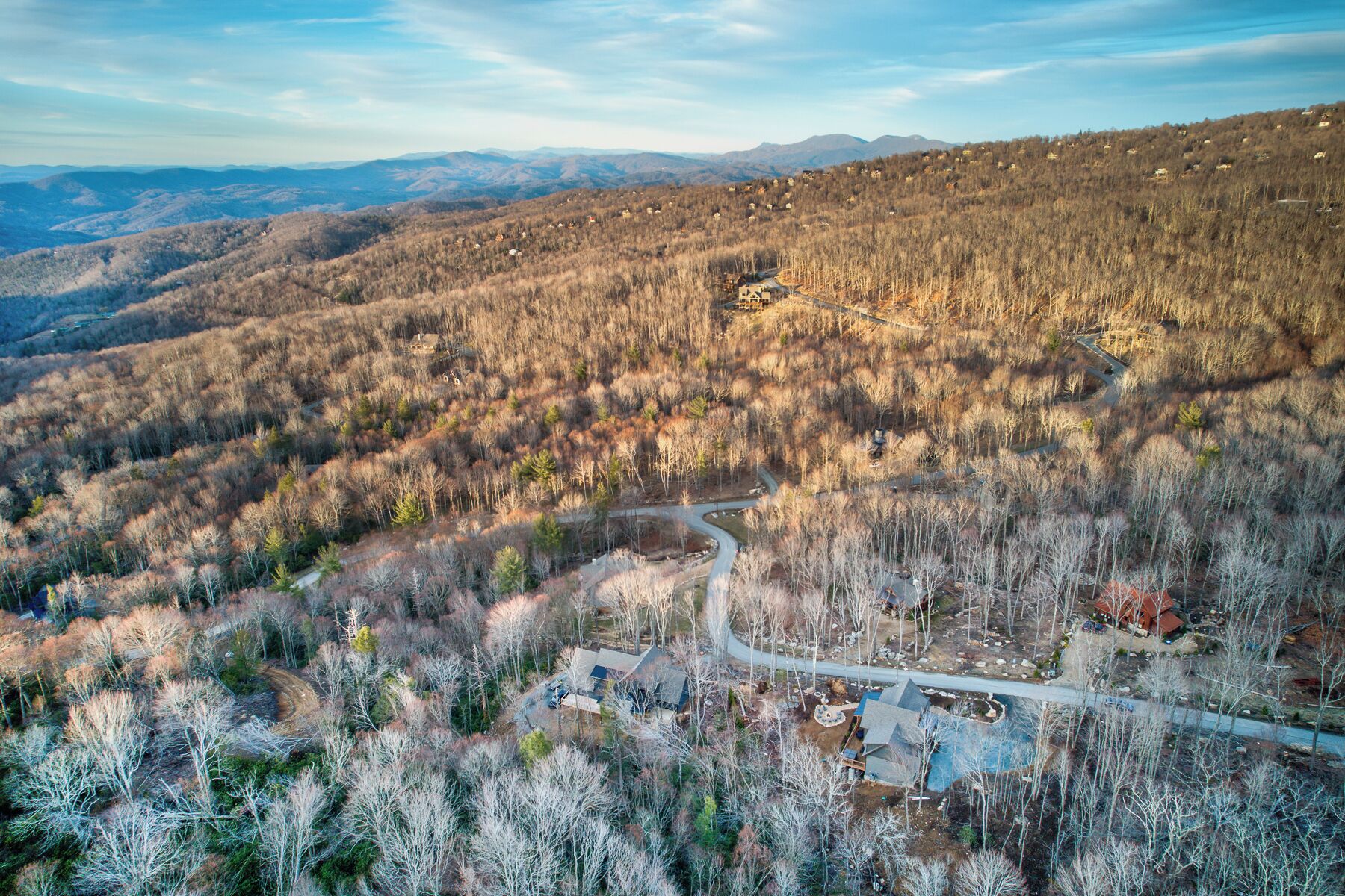 A mountainous landscape with scattered houses and a winding road.