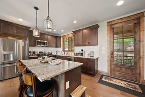 Eine moderne Küche mit Granit Arbeitsplatten, Edelstahlgeräten und Holzschränken.