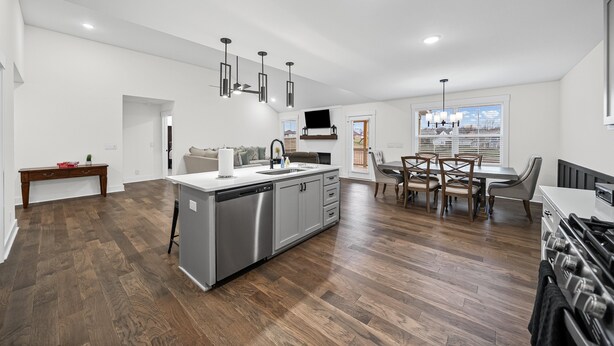 A modern kitchen with a central island, stainless steel appliances, and a dining area with a table and chairs.