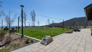 A paved outdoor area with seating, string lights, and a view of distant mountains.