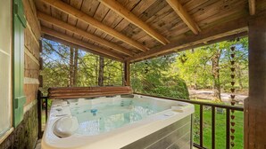 A hot tub under a wooden pergola with a view of a landscaped garden. - Bridgepoint Cabin Walk to Watauga River, hot Tub, Play in the Yard (Vilas)