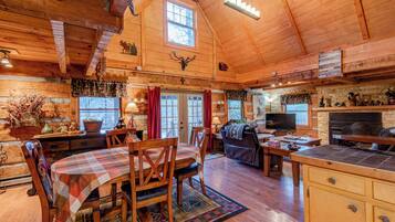 A cozy cabin interior with a dining area, a living room, and a kitchen.