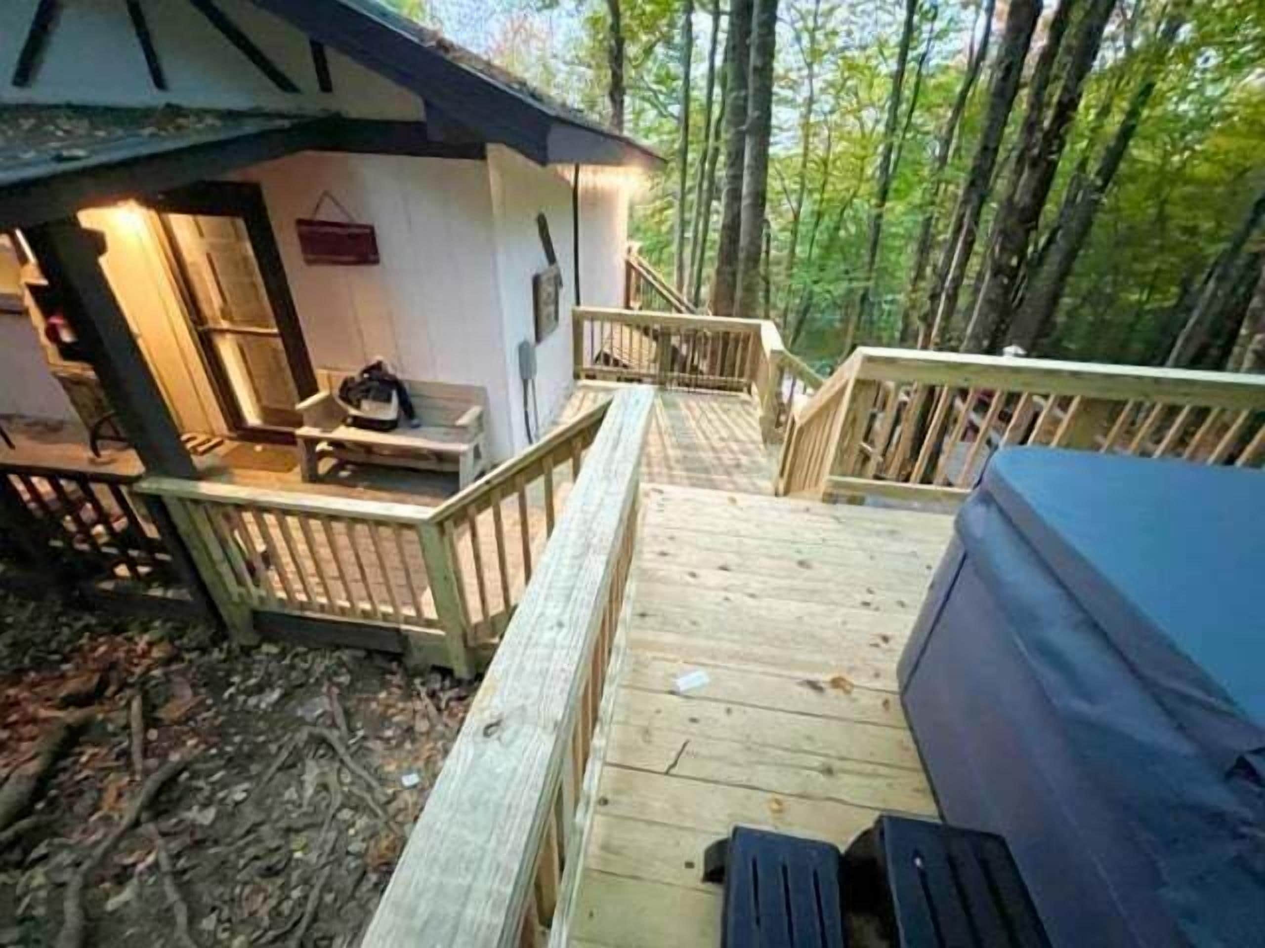 A wooden deck leading to a cabin with a small porch area.