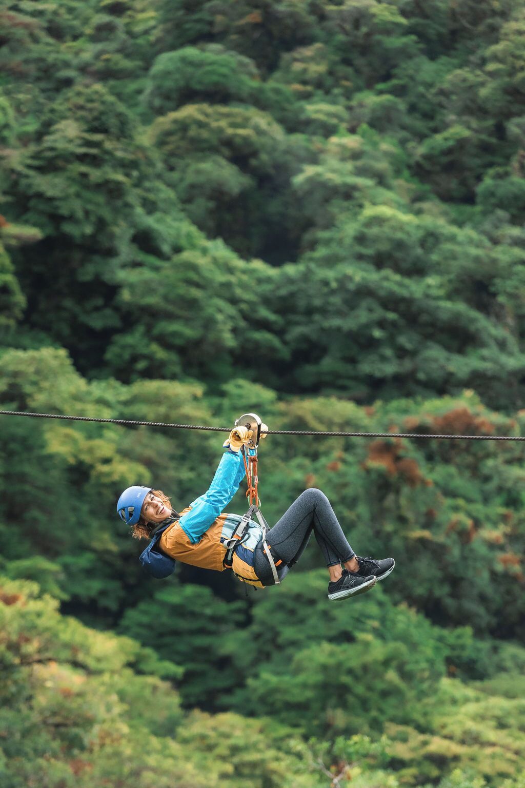 A person ziplining through a forest.