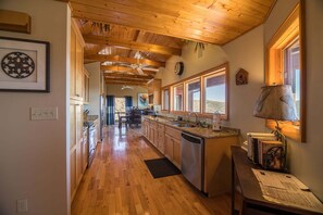 A kitchen with wooden beams, a central island, and a view of the outdoors. - A Nest With a View (Blowing Rock)