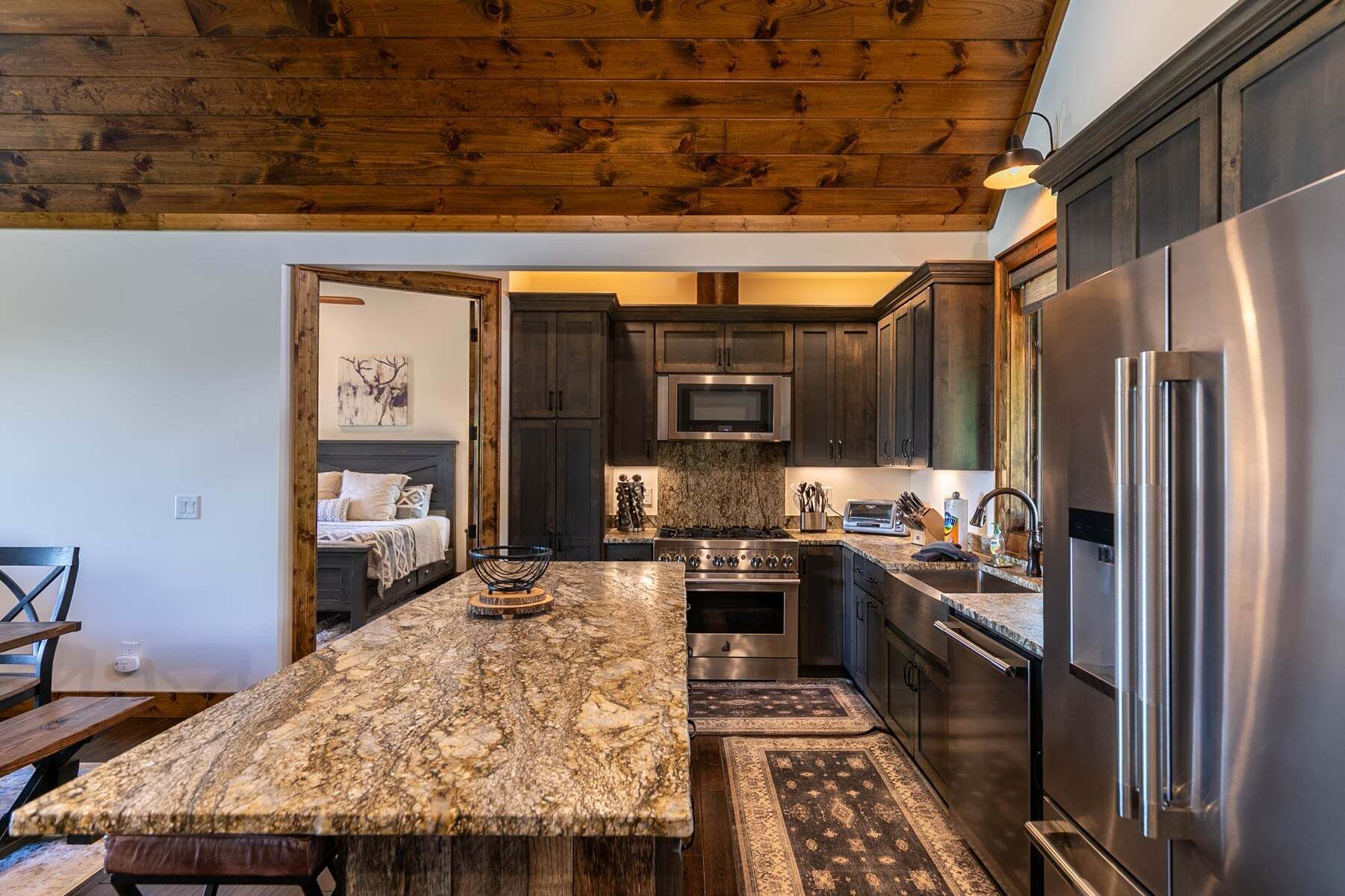 Una cocina con armarios de madera oscura, electrodomésticos de acero inoxidable y encimera de granito.