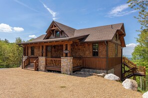 Eine Lodge mit steinernen Fundamenten, Holzfassade und einer Treppe zum Eingang.