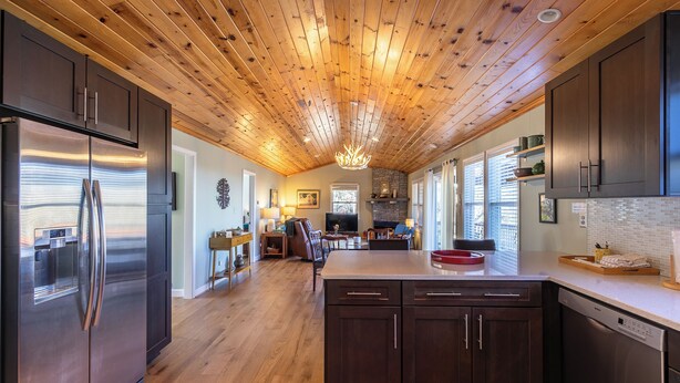 A modern kitchen with wooden ceiling, stainless steel appliances, and a central island. - High Ground One Level House - Pet Friendly (Boone)