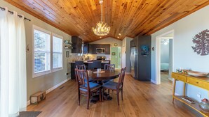 A dining area with a wooden ceiling, a chandelier, and a round table with chairs. - High Ground One Level House - Pet Friendly (Boone)