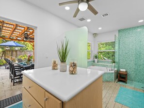 Eine moderne Küche mit weißer Arbeitsplatte, Holzschränken und einem Deckenventilator.