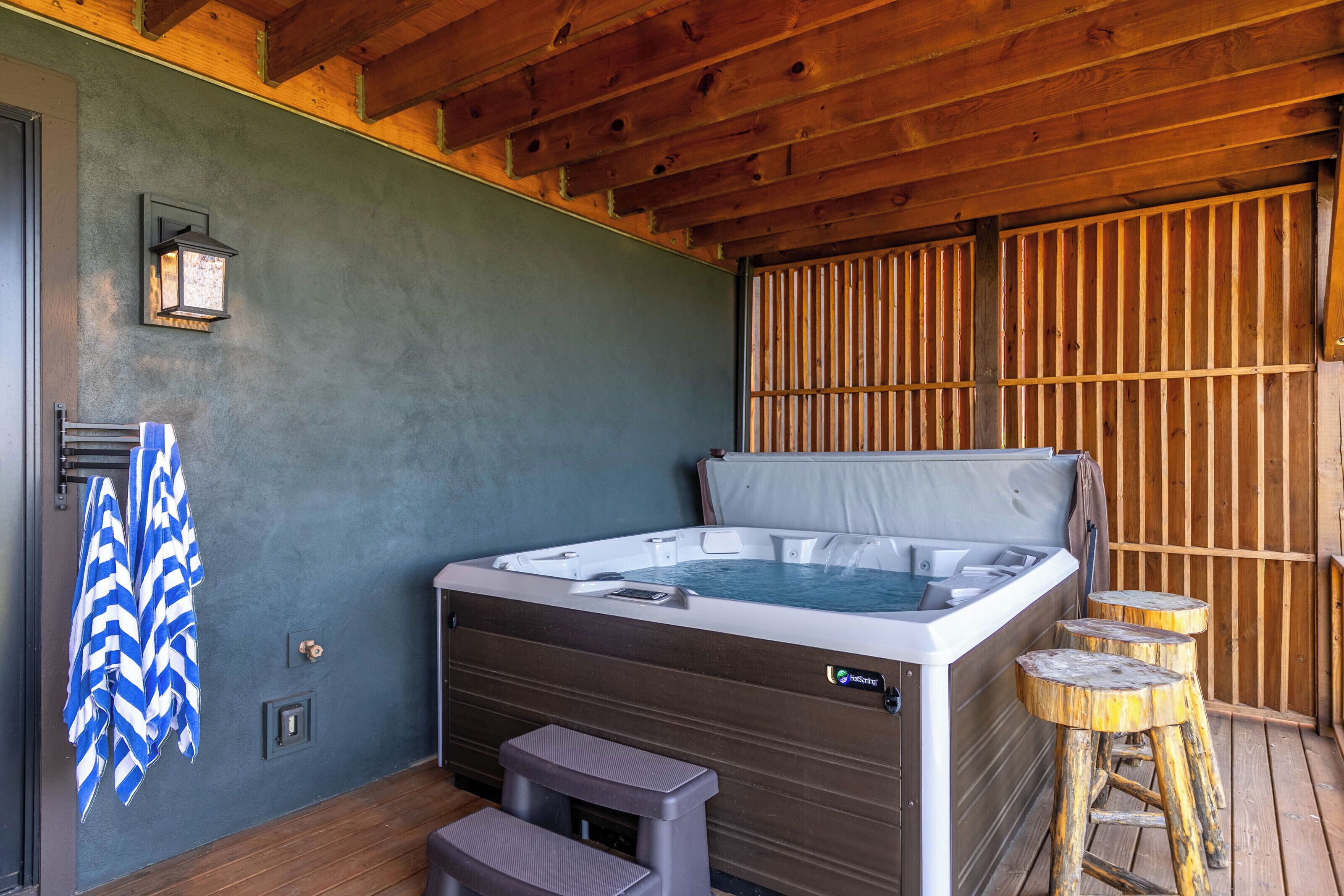 Un jacuzzi con muelle de madera, un perchero y dos taburetes.