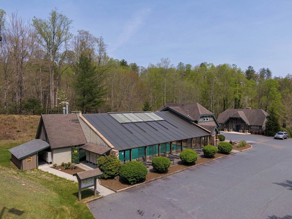 A lodge with a large building featuring a sloped roof and a smaller attached structure. - Still Lake Haven at Echota (Boone)