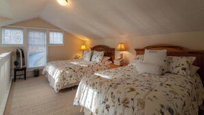 Un dormitorio con dos camas, ventilador de techo, calefactor y ventana con persianas.