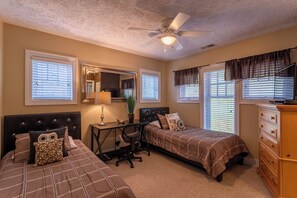 A bedroom with two beds, a desk, a chair, a dresser, and a ceiling fan. - Still Lake Haven at Echota (Boone)