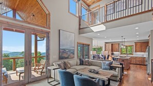 A spacious living area with a large sofa, blue armchairs, and a wooden coffee table. - Grandview Pointe (Banner Elk)