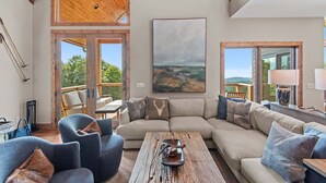 A spacious living area with a large sectional sofa, a coffee table, and a painting on the wall. - Grandview Pointe (Banner Elk)