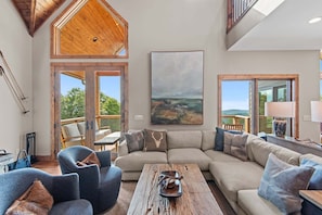 A spacious living area with a large sectional sofa, a coffee table, and a painting on the wall.
