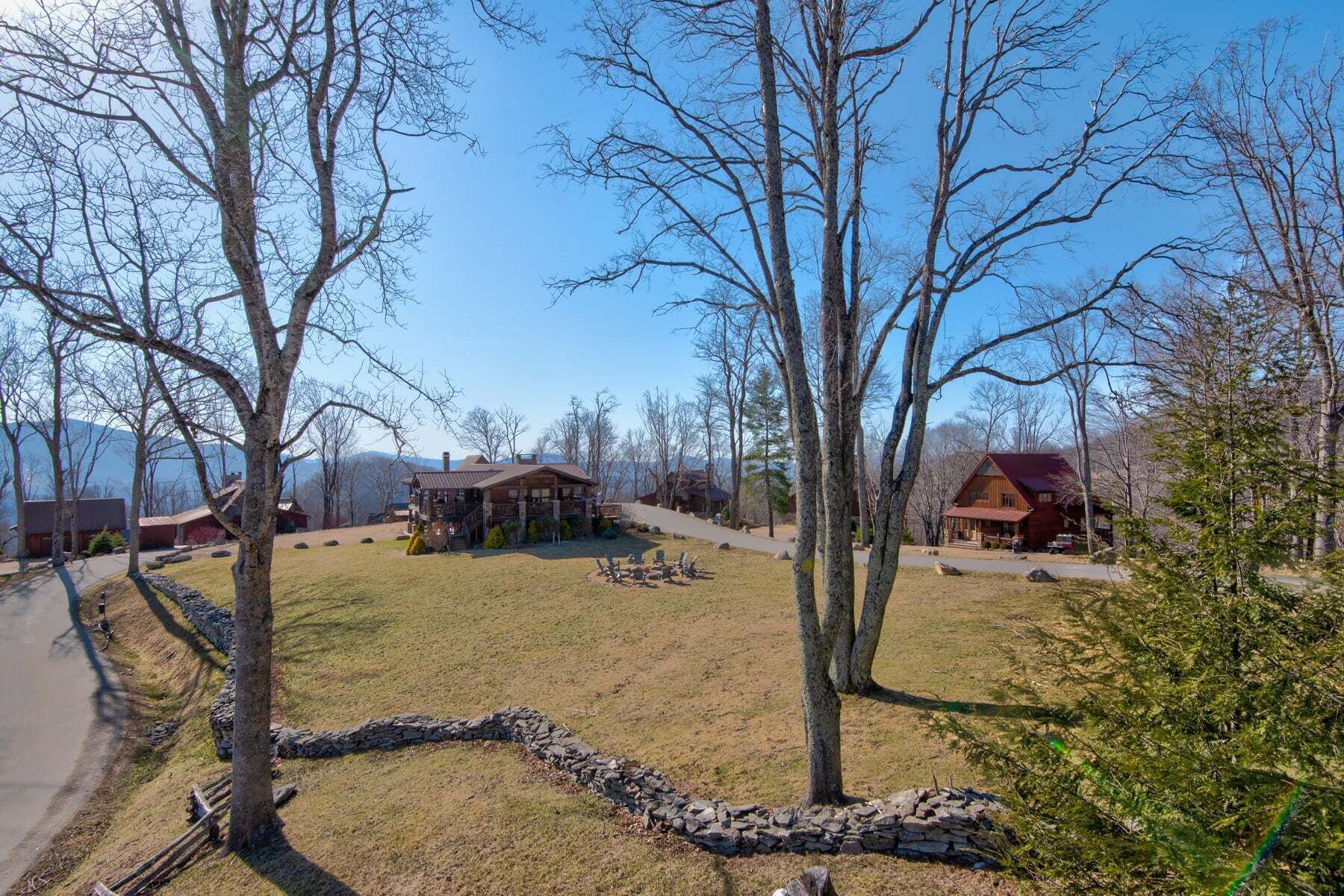 A lodge with a stone pathway, wooden deck, and multiple buildings with red roofs.