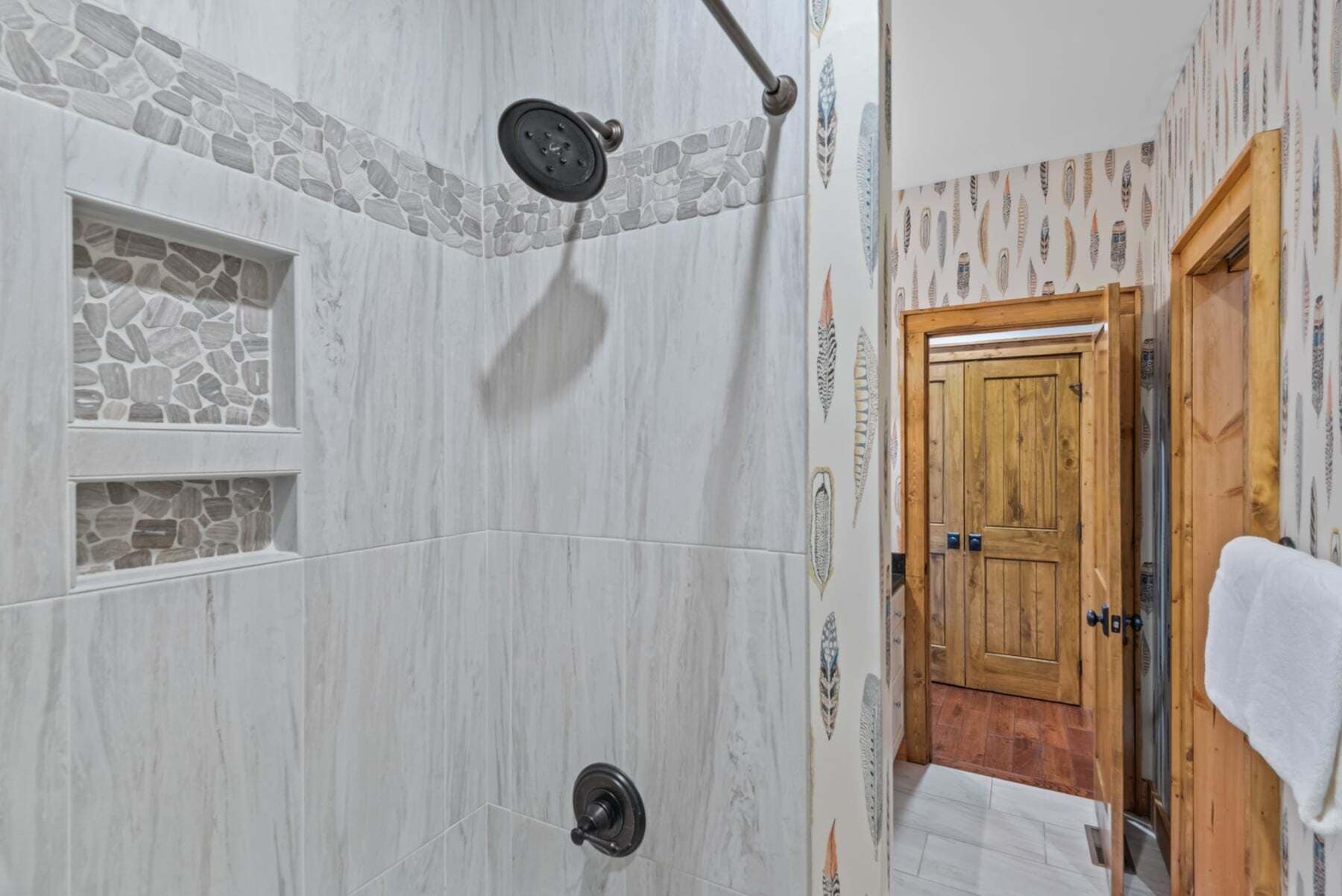 Een badkamer met een stenen muur, een douche en een houten deur.