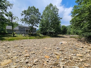 A residential area with a house, a gravel path, and a river. - Riverwood at Mill Ridge (Banner Elk)