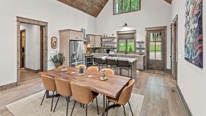 A spacious kitchen with a large island, wooden ceiling, and a view of the outdoors. - Streamsong at Eagles Nest (Banner Elk)