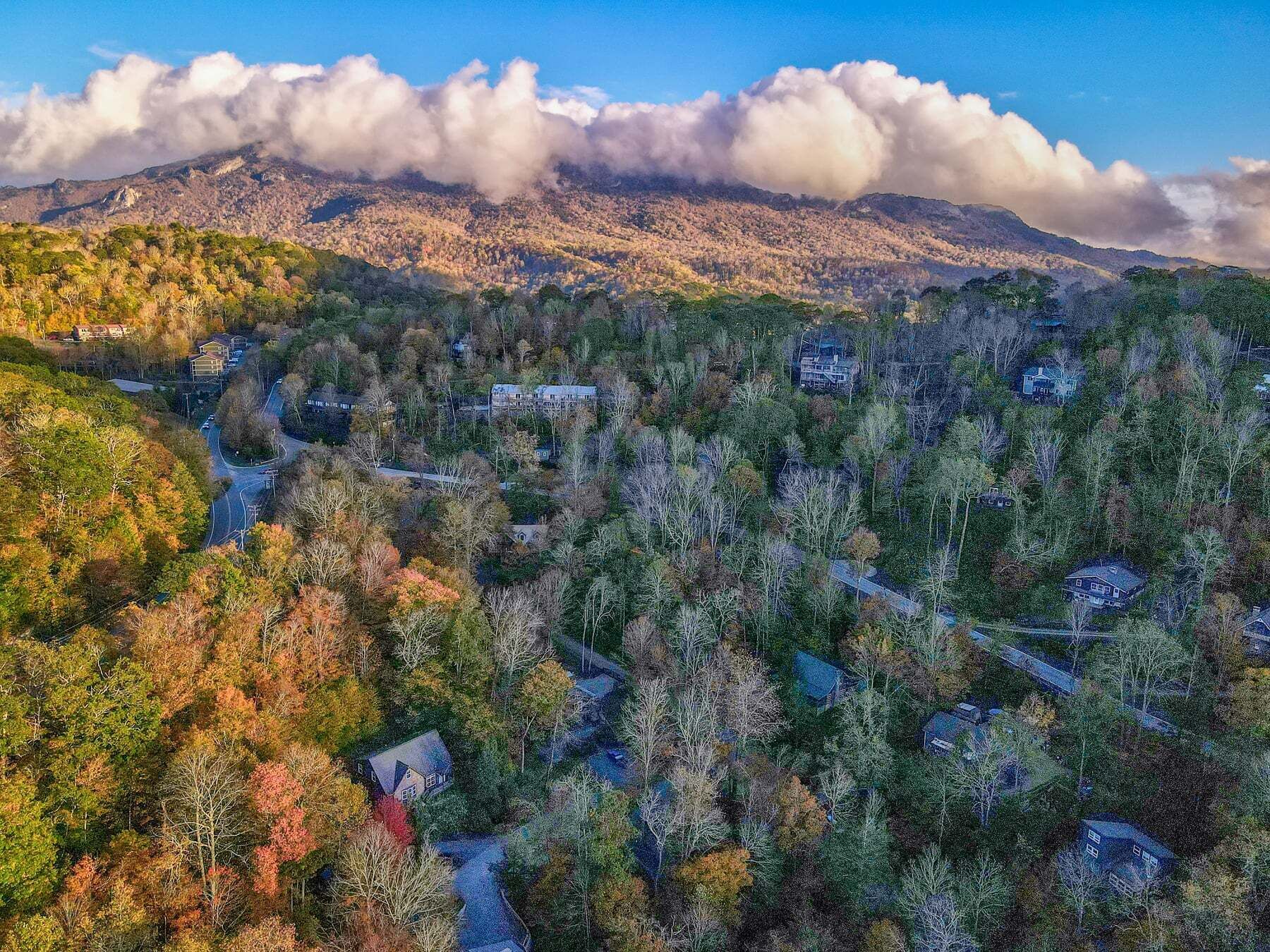 A mountainous landscape with scattered houses and winding roads.
