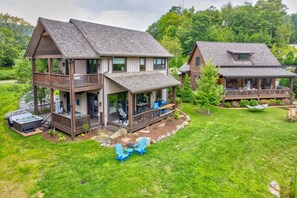 A two-story house with a deck, a hot tub, and a grassy yard. - Maynard Rocks IV at Elk Creek (Banner Elk)