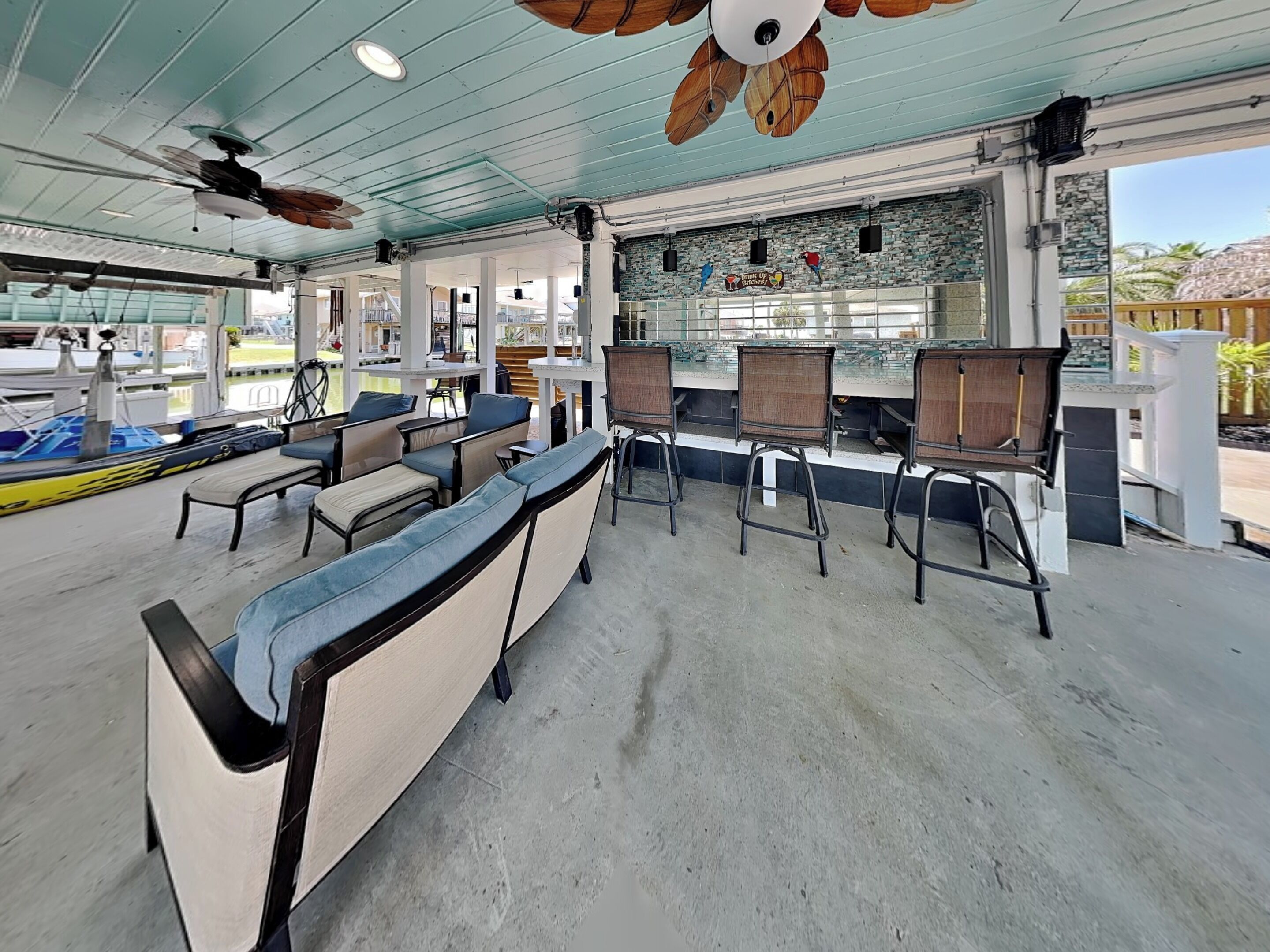A spacious indoor area with seating, ceiling fans, and a view of the outside.