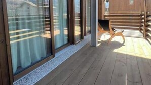 A wooden deck with large sliding glass doors, a wooden bench, and a view of the landscape. - 3 - Bormio Apartments Al Pradais - First P. WEST (Bormio)