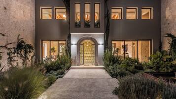 A modern two-story building with a central entrance, large windows, and a well-maintained garden.
