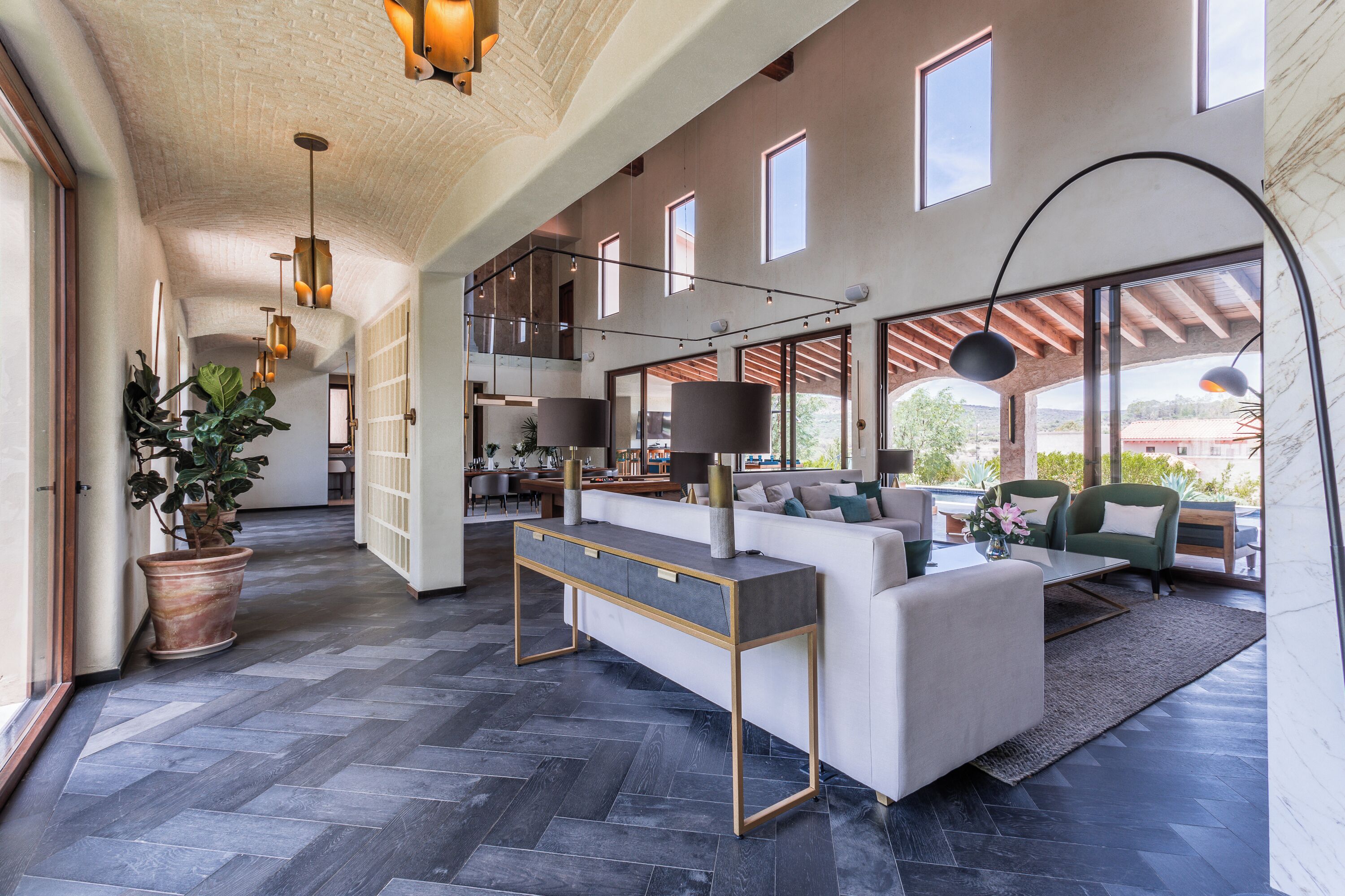 A spacious living area with a modern sofa, a coffee table, and a potted plant.