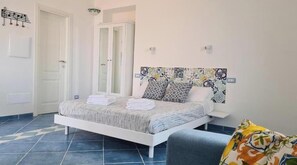 A bedroom with a bed, a chair, a wardrobe, and a door. - The little tower of Minuta - Allegro con Brio - retreat on the Amalfi Coast (Scala Costiera amalfitana)