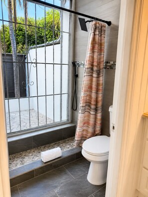 Een douche, handdoeken, zeep, toiletpapier