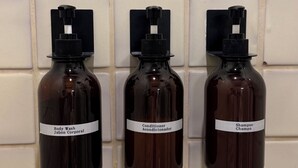 Three bottles of toiletries mounted on a tiled wall. - Verde Suite - Zona Romantica Suites (Puerto Vallarta)