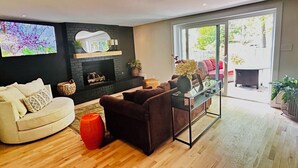 Een woonkamer met een open haard, een bank, een salontafel en een televisie.
