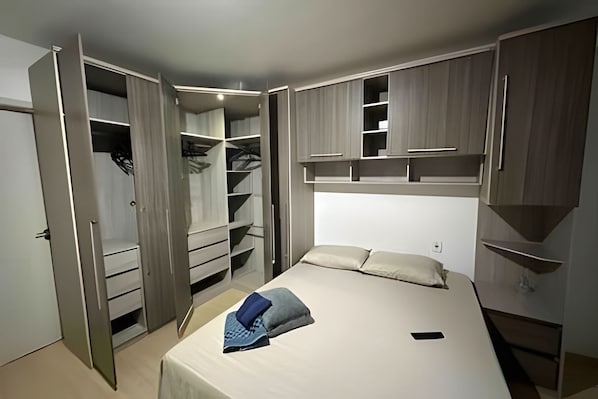 Ein Schlafzimmer mit einem Bett, einem Kleiderschrank und einem Einbauschrank.