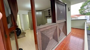 A room with a tiled floor, a door with a mirror, and a window with a decorative grille. - Quartos vila olímpia 43 (São Paulo)