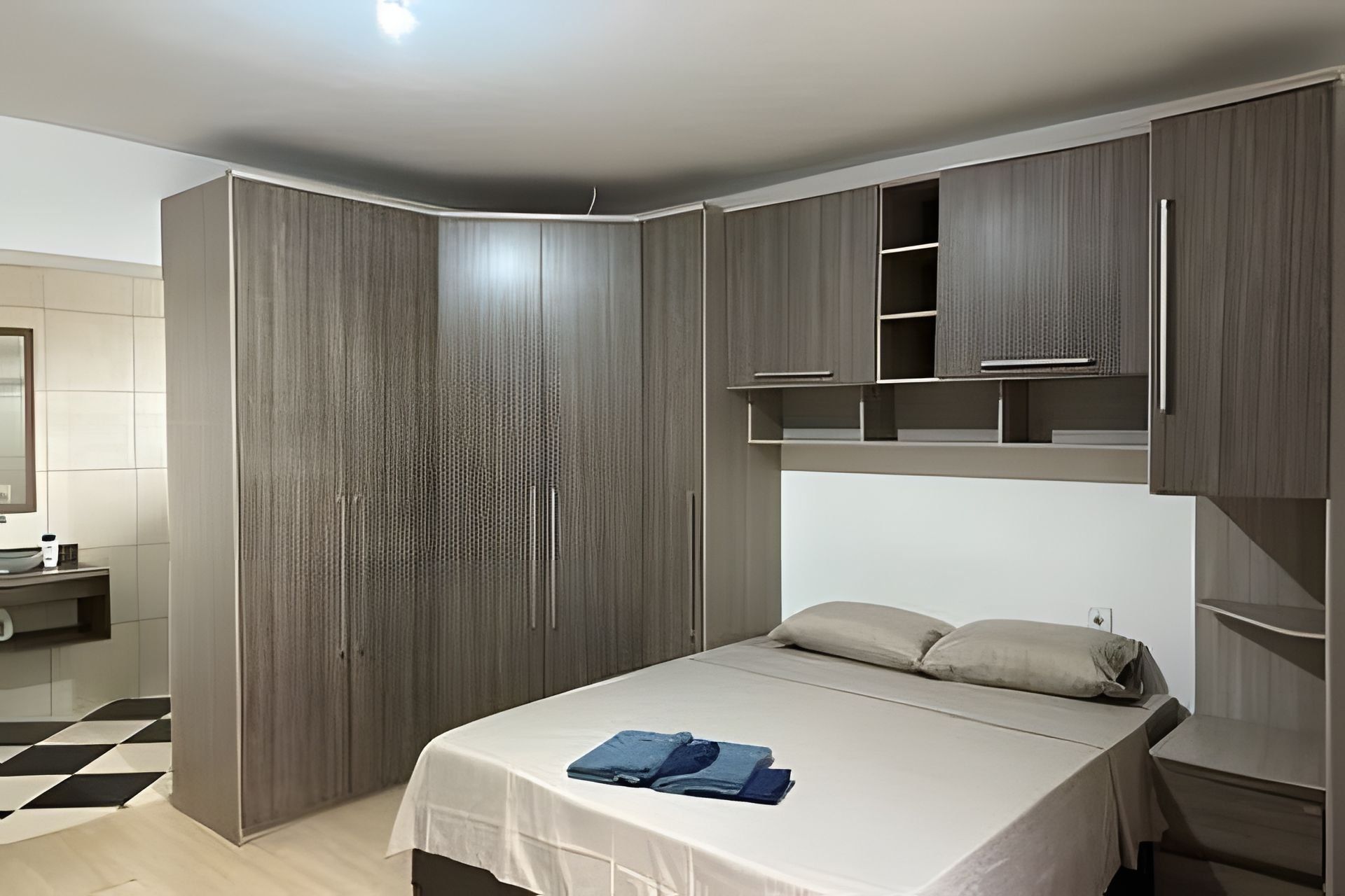 Un dormitorio con cama, armario y estantería empotrada.