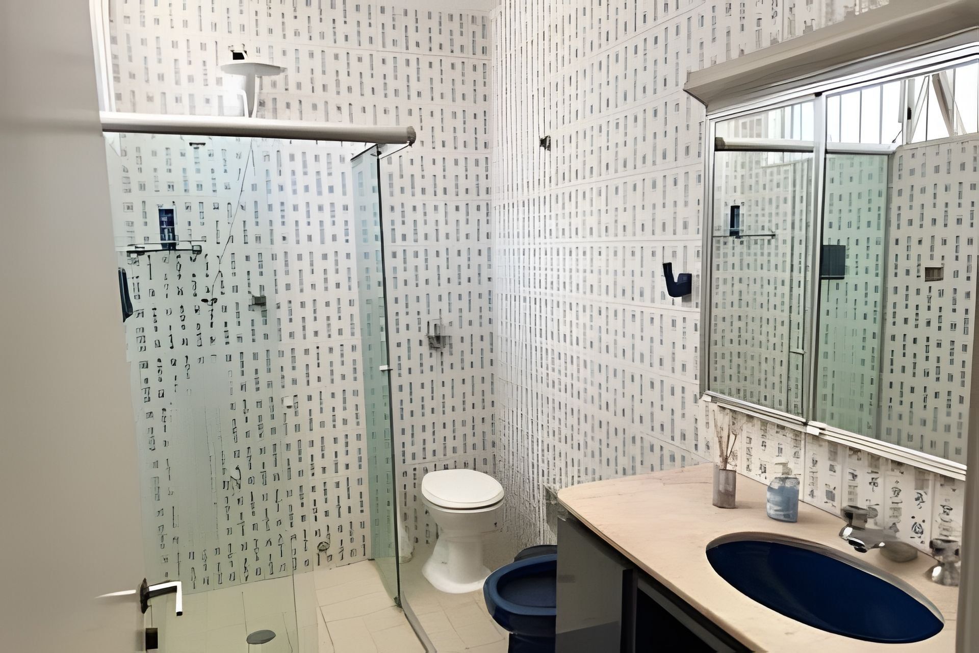 A bathroom with a glass shower enclosure, a toilet, and a sink with a mirror.