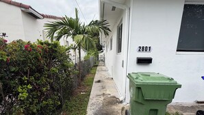 A narrow concrete pathway leading to a white building with the number 2801.
