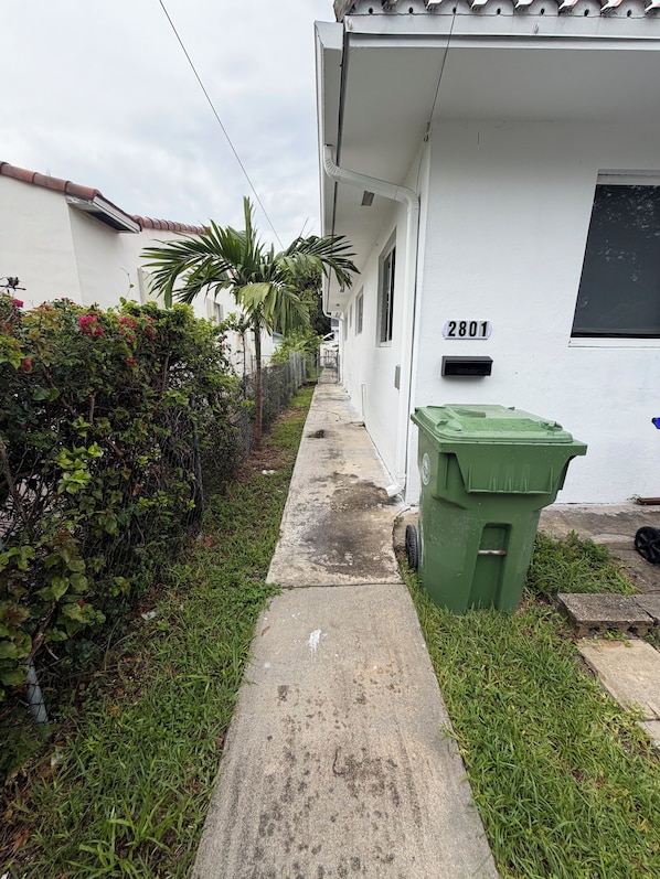 A narrow concrete pathway leading to a white building with the number 2801.
