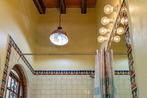 A bathroom with a tiled wall, a hanging light fixture, and a shower curtain. - Maito Suite - Romantic Zone (Puerto Vallarta)