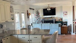 A kitchen with a central island, a dining area with a chair, and a living room with a couch. - Epic Mountain Views! Cool Weekend Retreat • Pet Friendly Near Charlette (Morganton)